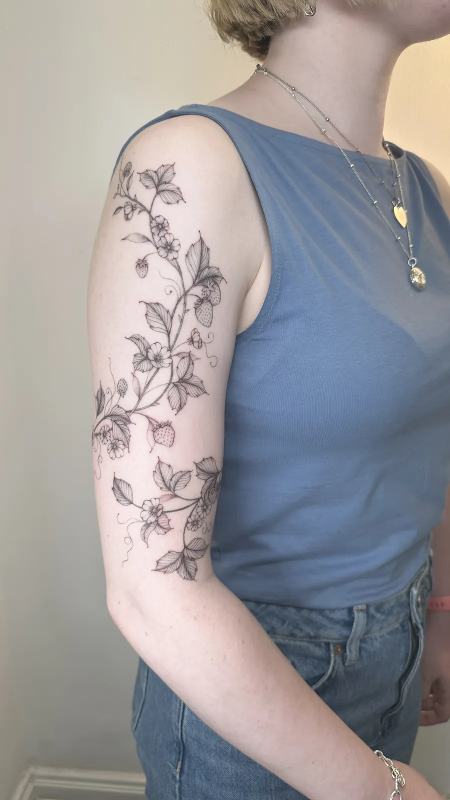 Morangos silvestres e flores subindo pelo braço