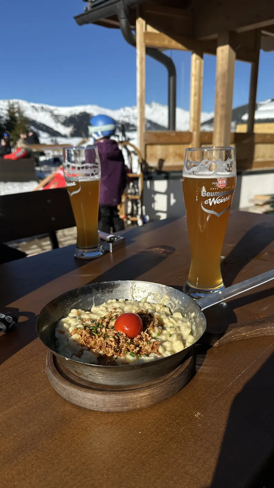 Spätzle e cerveja de trigo num terraço na montanha