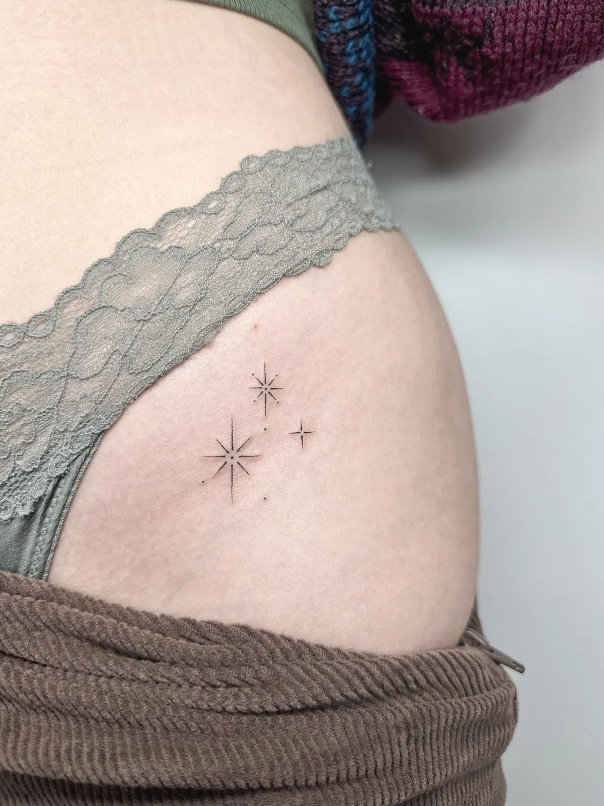 Três estrelas tatuadas no quadril
