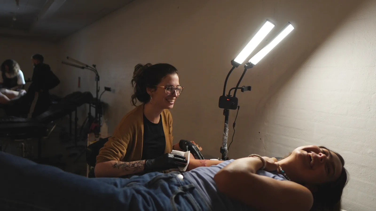 Talita sorrindo enquanto tatua no estúdio